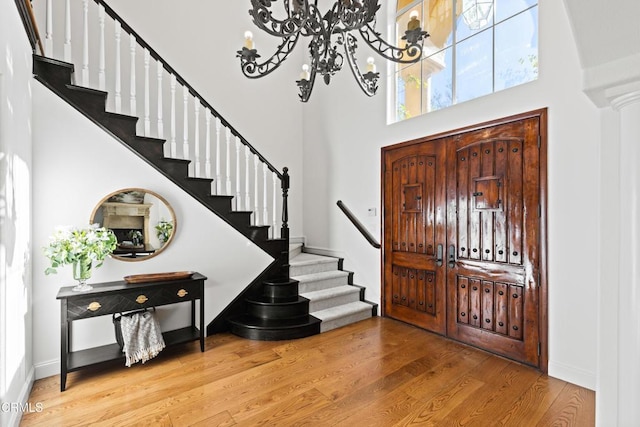 13045 Ripple Creek Ln, Camarillo, CA 93012 - entrance foyer with a chandelier, stairway, a high ceiling, wood finished floors, and baseboards