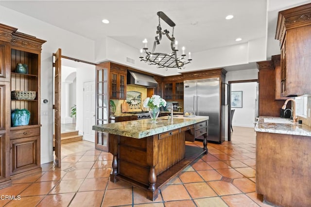 13045 Ripple Creek Ln, Camarillo, CA 93012 - kitchen featuring wall chimney exhaust hood, a sink, arched walkways, stainless steel built in fridge, and light tile patterned floors