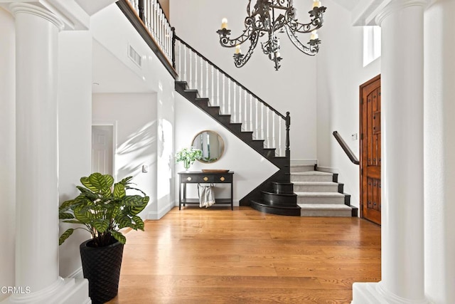 13045 Ripple Creek Ln, Camarillo, CA 93012 - entryway featuring ornate columns, stairway, a high ceiling, wood finished floors, and a chandelier