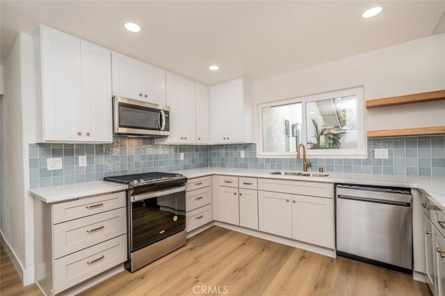 40033 Sagewood Dr, Palm Desert, CA 92260 - kitchen featuring appliances with stainless steel finishes, a sink, light countertops, light wood finished floors, and recessed lighting