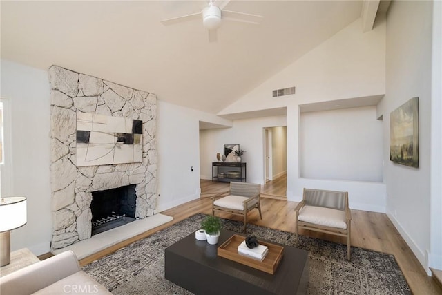 40033 Sagewood Dr, Palm Desert, CA 92260 - living room featuring a ceiling fan, wood finished floors, a stone fireplace, baseboards, and high vaulted ceiling