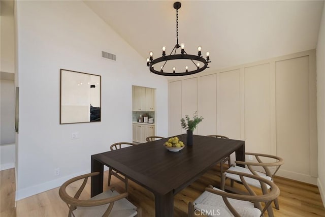 40033 Sagewood Dr, Palm Desert, CA 92260 - dining area featuring a chandelier, light wood finished floors, baseboards, and high vaulted ceiling