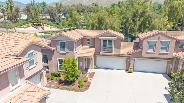 29290 Morena Villa Dr, Highland, CA 92346 - view of front of property with an attached garage, a mountain view, concrete driveway, a tile roof, and stucco siding