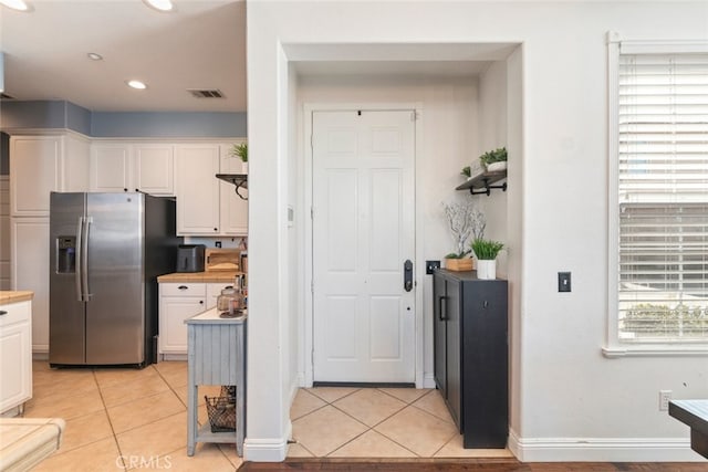 29290 Morena Villa Dr, Highland, CA 92346 - kitchen featuring stainless steel fridge, white cabinetry, light tile patterned flooring, and recessed lighting