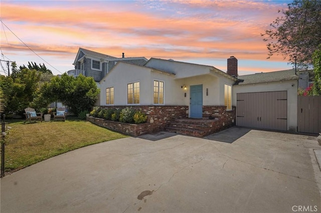 1120 9th St, Hermosa Beach, CA 90254 - view of front of house with driveway, a chimney, a garage, stucco siding, and brick siding