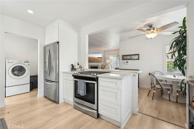 1120 9th St, Hermosa Beach, CA 90254 - kitchen featuring appliances with stainless steel finishes, washer / dryer, white cabinetry, light wood-type flooring, and a peninsula