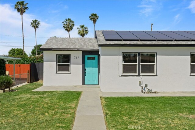 764 N Meridian Ave, Rialto, CA 92376 - view of front of house featuring solar panels, roof with shingles, and stucco siding