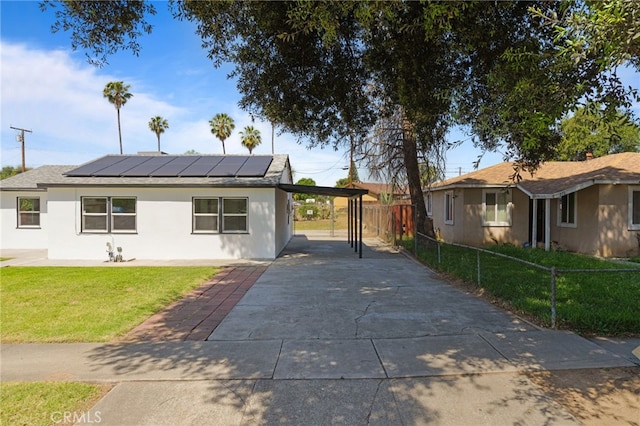 764 N Meridian Ave, Rialto, CA 92376 - view of front of house featuring driveway, a carport, roof mounted solar panels, and stucco siding