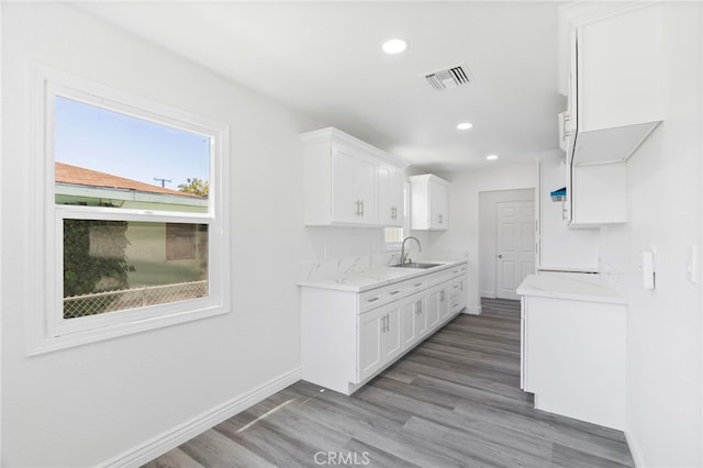 764 N Meridian Ave, Rialto, CA 92376 - kitchen with a sink, wood finished floors, baseboards, white cabinetry, and recessed lighting