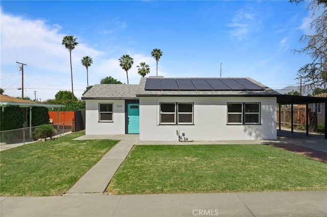 764 N Meridian Ave, Rialto, CA 92376 - view of front facade featuring solar panels, stucco siding, a shingled roof, and a carport