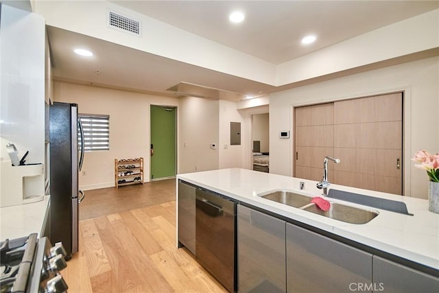 820 S Wilton Pl Unit 304, Los Angeles, CA 90005 - kitchen with stainless steel appliances, a sink, light wood-style floors, electric panel, and recessed lighting