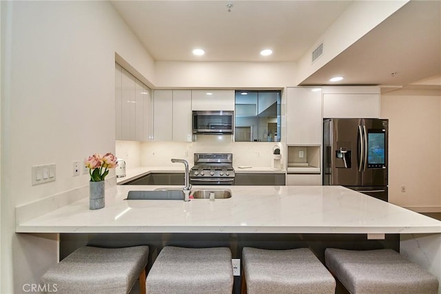 820 S Wilton Pl Unit 304, Los Angeles, CA 90005 - kitchen with stainless steel appliances, a sink, modern cabinets, a peninsula, and white cabinets