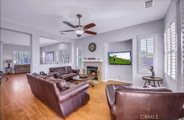 80804 Sunspring Ct, Indio, CA 92201 - living room with a ceiling fan, a tile fireplace, wood finished floors, and baseboards