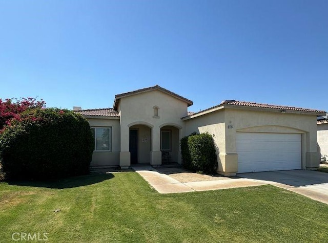80804 Sunspring Ct, Indio, CA 92201 - mediterranean / spanish house featuring stucco siding, driveway, a tile roof, a front yard, and an attached garage