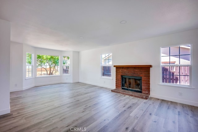 1264 W Etiwanda Ave, Rialto, CA 92376 - unfurnished living room featuring wood finished floors, baseboards, and a brick fireplace