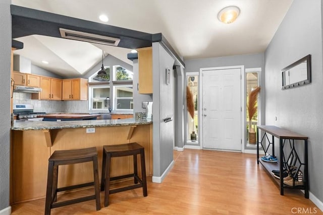8510 Verdant Ct, Los Molinos, CA 96055 - kitchen featuring under cabinet range hood, stainless steel range with gas cooktop, light wood-type flooring, light stone counters, and lofted ceiling