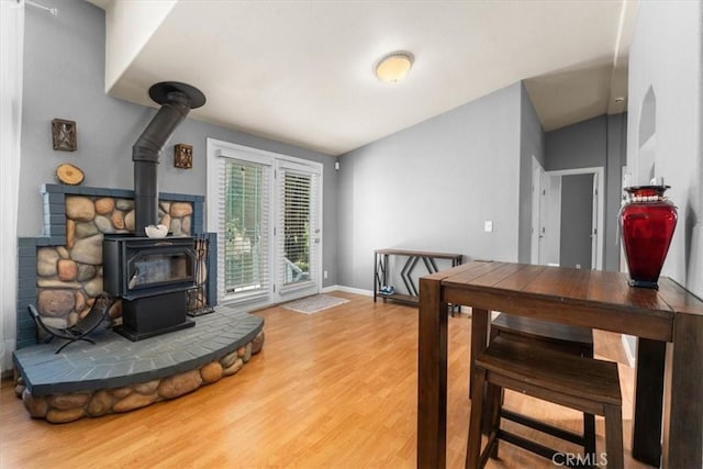 8510 Verdant Ct, Los Molinos, CA 96055 - dining room with a wood stove, wood finished floors, lofted ceiling, and baseboards