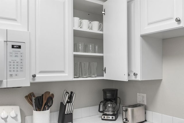 6955 Alvarado Rd Unit 77, San Diego, CA 92120 - kitchen view of white microwave, white cabinetry, and light countertops