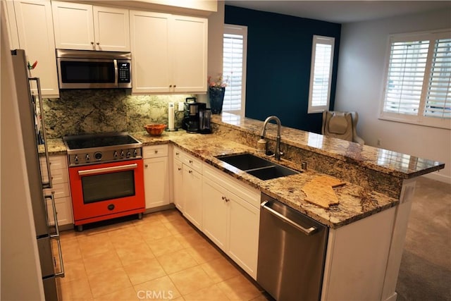 1104 Hibiscus Way, Oceanside, CA 92054 - kitchen featuring stainless steel appliances, a peninsula, a sink, white cabinets, and decorative backsplash