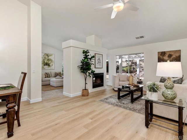 1219 Sunglow Dr, Oceanside, CA 92056 - living room with light wood-style flooring, a ceiling fan, vaulted ceiling, a glass covered fireplace, and baseboards