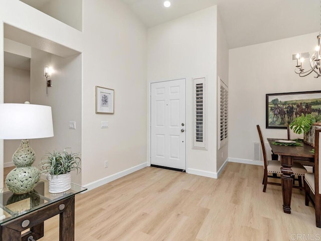 1219 Sunglow Dr, Oceanside, CA 92056 - entryway featuring a chandelier, light wood-type flooring, high vaulted ceiling, and baseboards