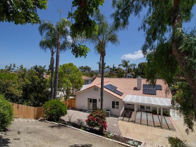 1219 Sunglow Dr, Oceanside, CA 92056 - rear view of house with solar panels, a tiled roof, stucco siding, a patio, and central AC