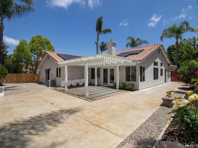 1219 Sunglow Dr, Oceanside, CA 92056 - rear view of property featuring a pergola, solar panels, a tile roof, a patio, and a fenced backyard