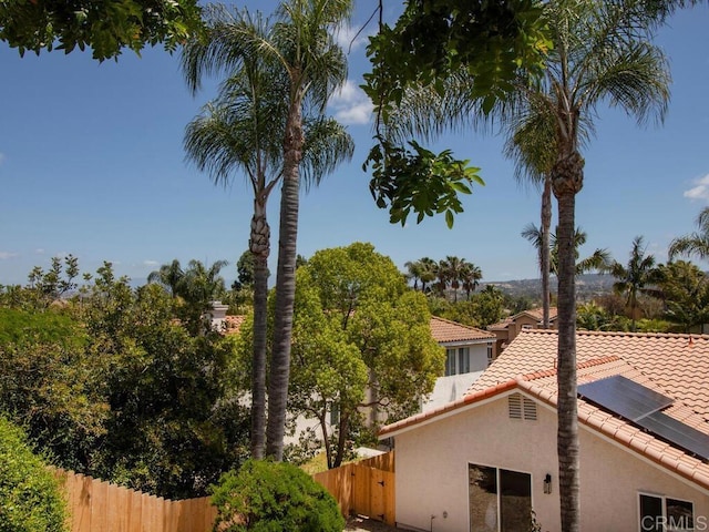1219 Sunglow Dr, Oceanside, CA 92056 - view of side of home featuring a tiled roof, solar panels, and stucco siding