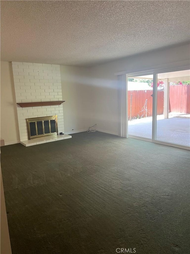 2306 S Rene Dr, Santa Ana, CA 92704 - unfurnished living room with a textured ceiling, dark colored carpet, baseboards, and a fireplace