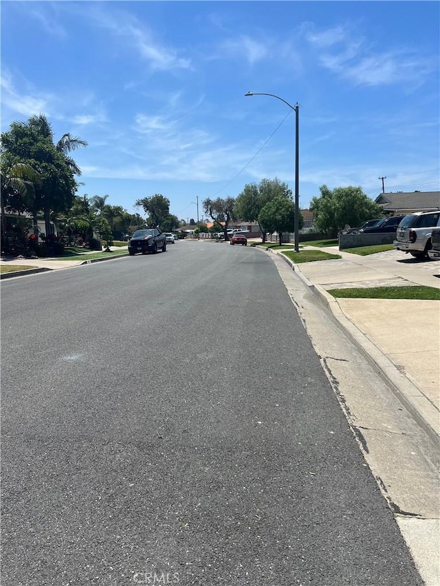 2306 S Rene Dr, Santa Ana, CA 92704 - view of asphalt road featuring curbs, street lighting, and sidewalks