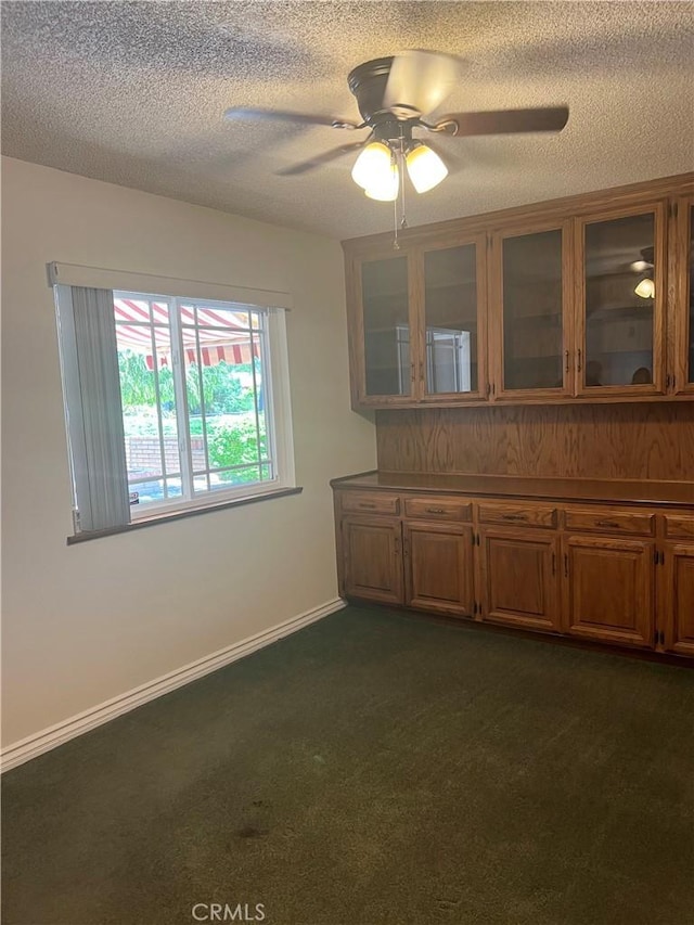 2306 S Rene Dr, Santa Ana, CA 92704 - unfurnished dining area featuring a ceiling fan, a textured ceiling, dark carpet, and baseboards