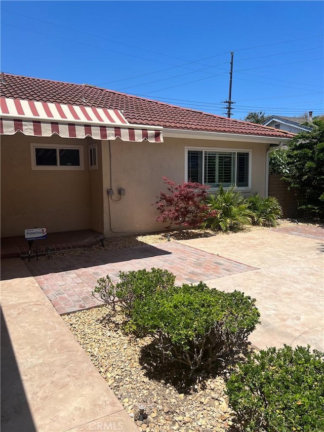 2306 S Rene Dr, Santa Ana, CA 92704 - view of front of house featuring a tiled roof, stucco siding, and a patio area