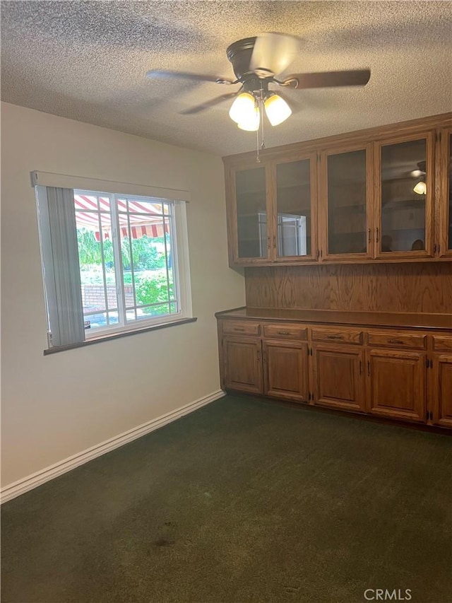 2306 S Rene Dr, Santa Ana, CA 92704 - unfurnished dining area featuring ceiling fan, a textured ceiling, dark colored carpet, and baseboards