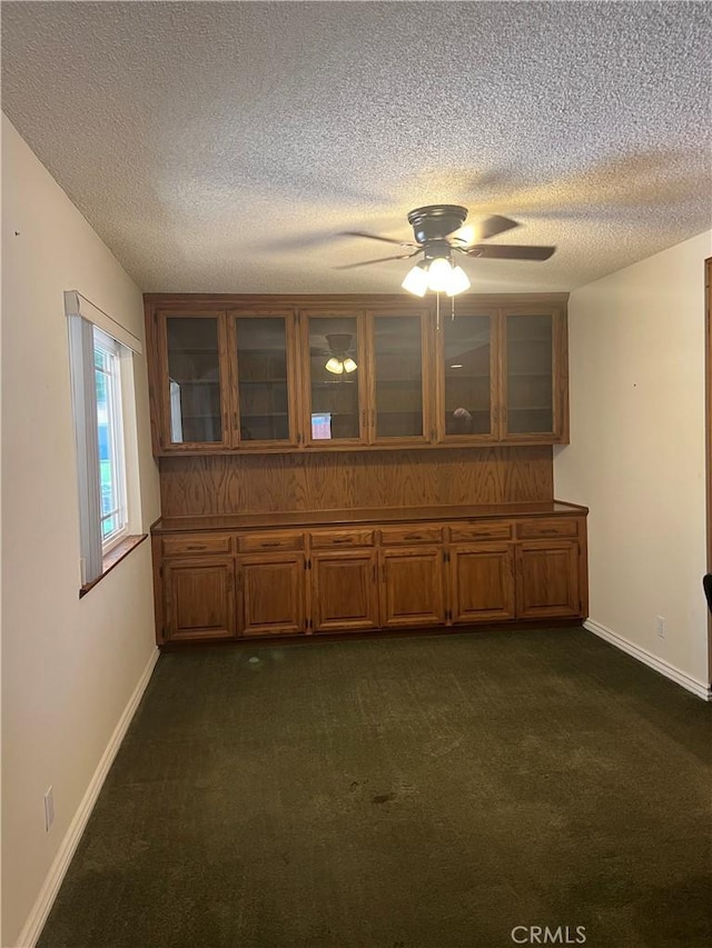 2306 S Rene Dr, Santa Ana, CA 92704 - spare room with ceiling fan, a textured ceiling, dark colored carpet, and baseboards