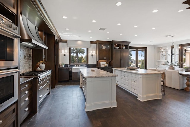 2574 Muirfields Dr, Carlsbad, CA 92009 - kitchen with a kitchen island, healthy amount of natural light, dark brown cabinets, backsplash, and recessed lighting