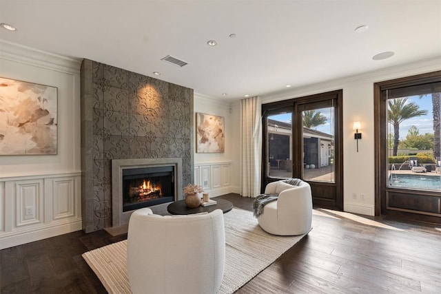 2574 Muirfields Dr, Carlsbad, CA 92009 - living room featuring healthy amount of natural light, ornamental molding, a large fireplace, wood finished floors, and recessed lighting