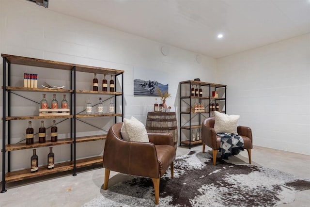 2574 Muirfields Dr, Carlsbad, CA 92009 - living area featuring concrete flooring, a bar, and concrete block wall