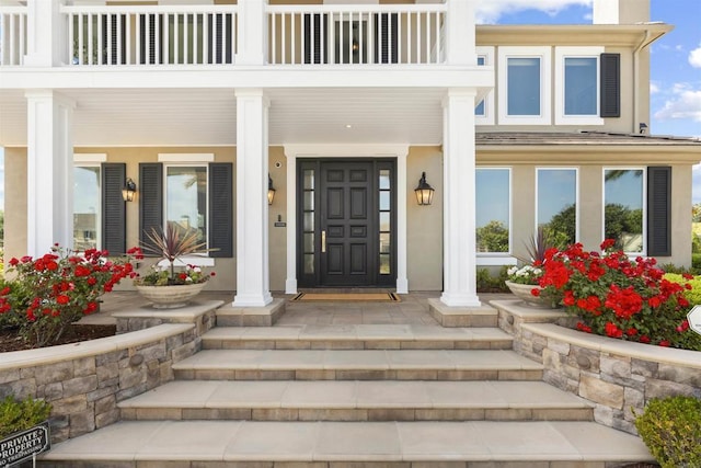 2574 Muirfields Dr, Carlsbad, CA 92009 - view of exterior entry featuring a porch, a balcony, and stucco siding