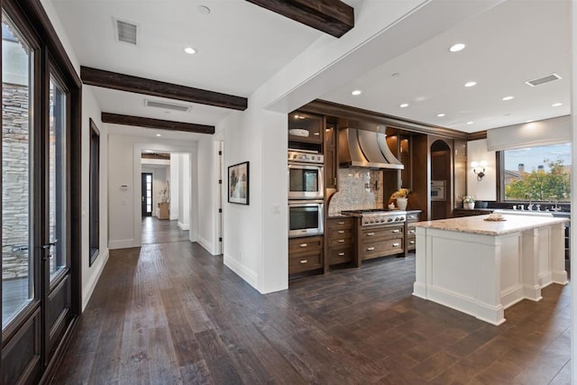 2574 Muirfields Dr, Carlsbad, CA 92009 - kitchen featuring wall chimney range hood, stainless steel appliances, beamed ceiling, backsplash, and dark wood finished floors