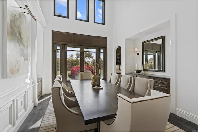 2574 Muirfields Dr, Carlsbad, CA 92009 - dining area featuring arched walkways, dark wood-style floors, and a high ceiling
