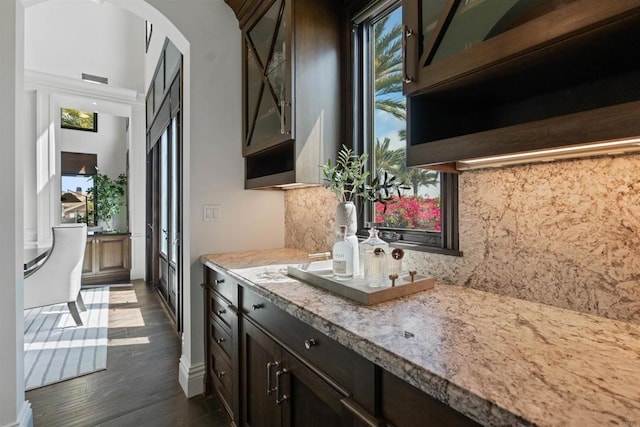 2574 Muirfields Dr, Carlsbad, CA 92009 - bar featuring dark wood-style flooring, tasteful backsplash, and a towering ceiling