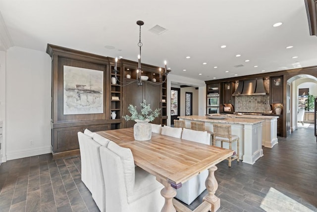 2574 Muirfields Dr, Carlsbad, CA 92009 - dining space featuring arched walkways, recessed lighting, ornamental molding, and dark wood-style floors