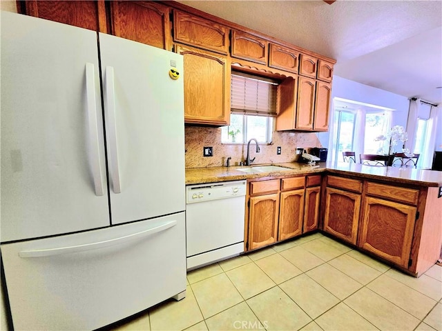 39560 S Lilley Way, Coarsegold, CA 93614 - kitchen featuring white appliances, a sink, brown cabinetry, a peninsula, and tasteful backsplash