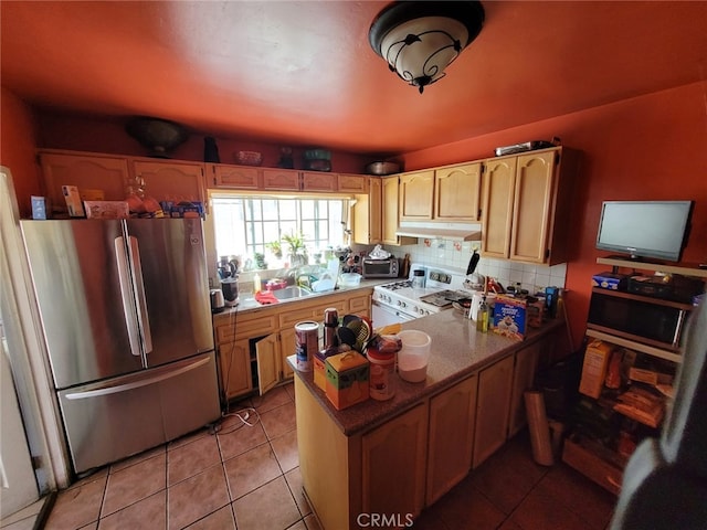 2920 Van Buren Pl, Los Angeles, CA 90007 - kitchen with freestanding refrigerator, white gas stove, under cabinet range hood, a peninsula, and backsplash