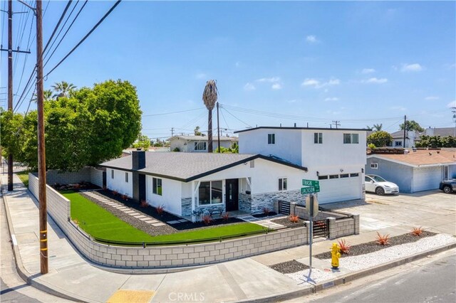 13502 Jackson St, Westminster, CA 92683 - view of front facade featuring concrete driveway, stucco siding, stone siding, and an attached garage