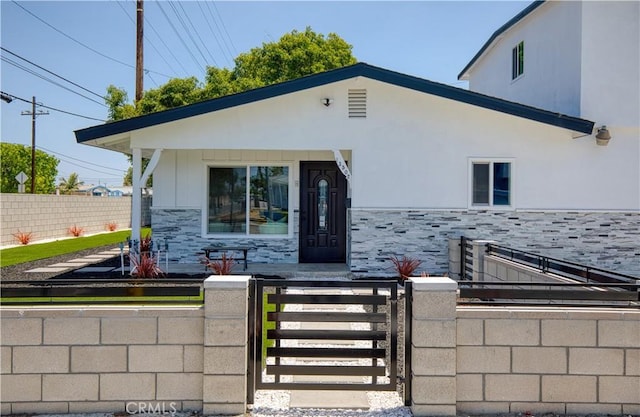 13502 Jackson St, Westminster, CA 92683 - view of front facade with a fenced front yard, stone siding, a gate, and stucco siding
