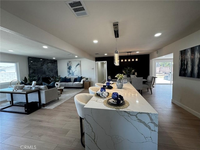 13502 Jackson St, Westminster, CA 92683 - kitchen with light wood-style floors, recessed lighting, a breakfast bar, baseboards, and pendant lighting