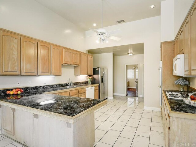 10237 High Mountain Dr, Escondido, CA 92026 - kitchen with appliances with stainless steel finishes, a peninsula, dark countertops, light marble finish floors, and a ceiling fan