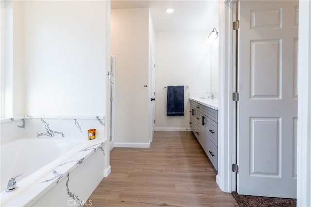 21402 Short Ridge Ave, Perris, CA 92570 - full bath featuring vanity, a garden tub, wood finished floors, and baseboards