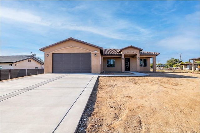 21402 Short Ridge Ave, Perris, CA 92570 - mediterranean / spanish-style home featuring driveway, stucco siding, an attached garage, and a tiled roof